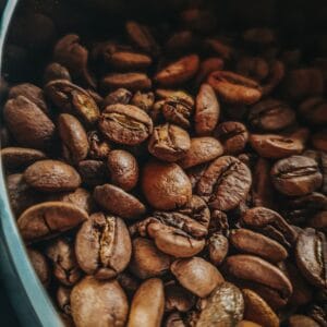 Detailed view of roasted coffee beans in a container in São Paulo, capturing rich textures and earthy tones.